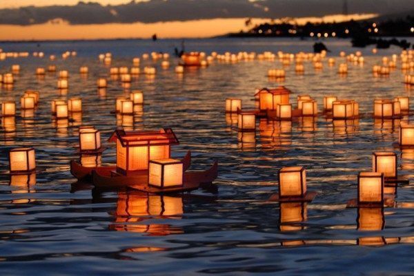Farolillos (toro nagashi) flotando en la noche de Obon en Japón