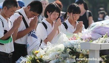 Personas rezando en el acto de homenaje a las víctimas de la bomba atómica de Hiroshima