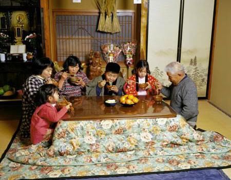 Familia japonesa cenando en torno a un "kotatsu" o mesa con calefacción