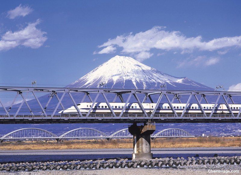 Tren bala o Shinkansen cruzando un puente por delante del Monte Fuji