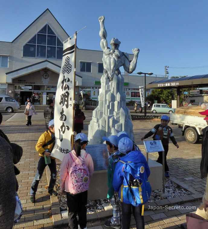 Festival Taimatsu Akashi: niños mirando una estatua de personaje de manga delante de la estación de Sukagawa el día del ritual de fuego