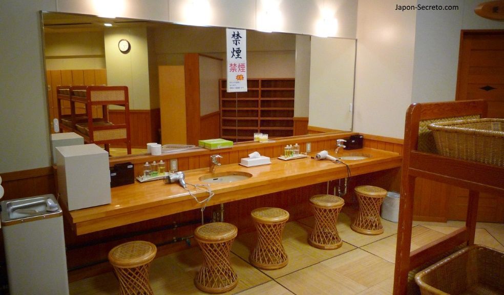 Baños tradicionales en Japón: zona de vestuarios de un onsen. Cestas para la ropa a la derecha.