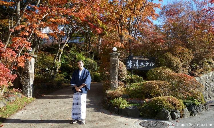 En la puerta del Kusatsu Hotel vestido con yukata durante el momiji (otoño)