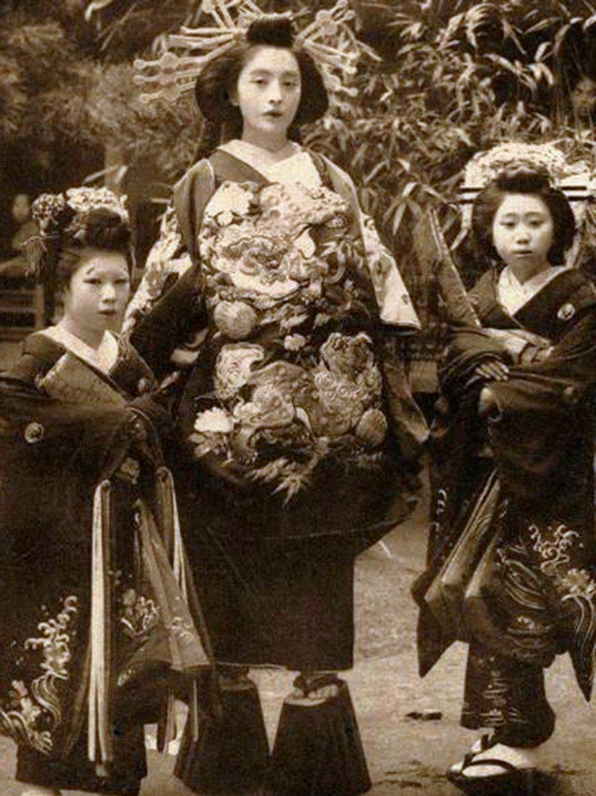 Foto antigua de oiran (prostituta japonesa) acompañada de aprendices ("kamuro").