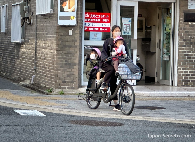 Madre transportando a sus hijos en bicicleta por las calles de Kioto