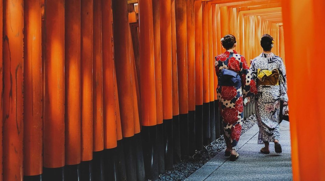 Chicas en kimono paseando por el túnel de toriis del santuario Fushimi Inari Taisha de Kioto