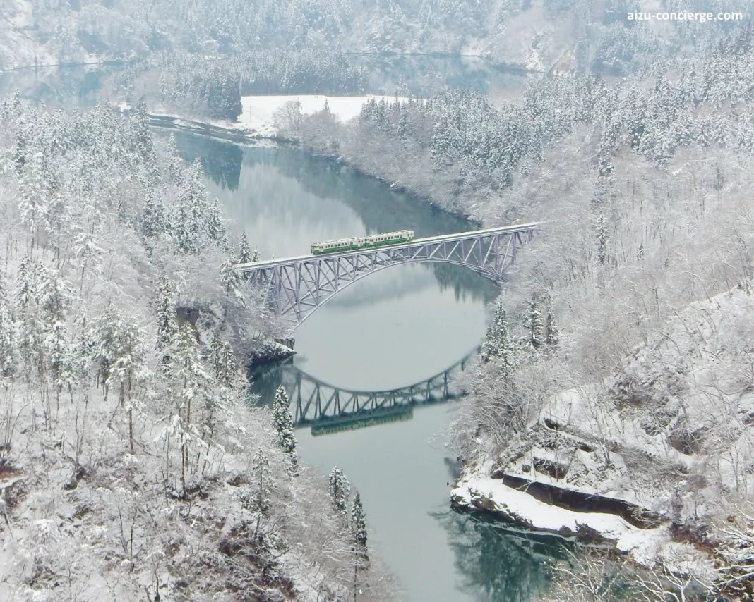 Línea Tadami de tren en Fukushima en invierno. Paisaje nevado y tren pasando por el puente.