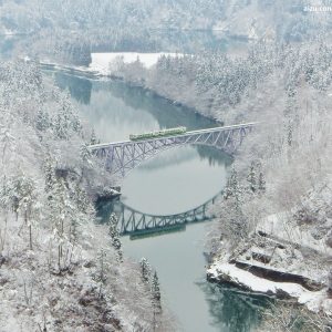 Línea Tadami de tren en Fukushima en invierno. Paisaje nevado y tren pasando por el puente.