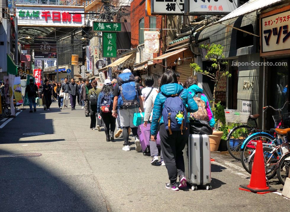 Turistas arrastrando pesado equipaje en Namba (Osaka)