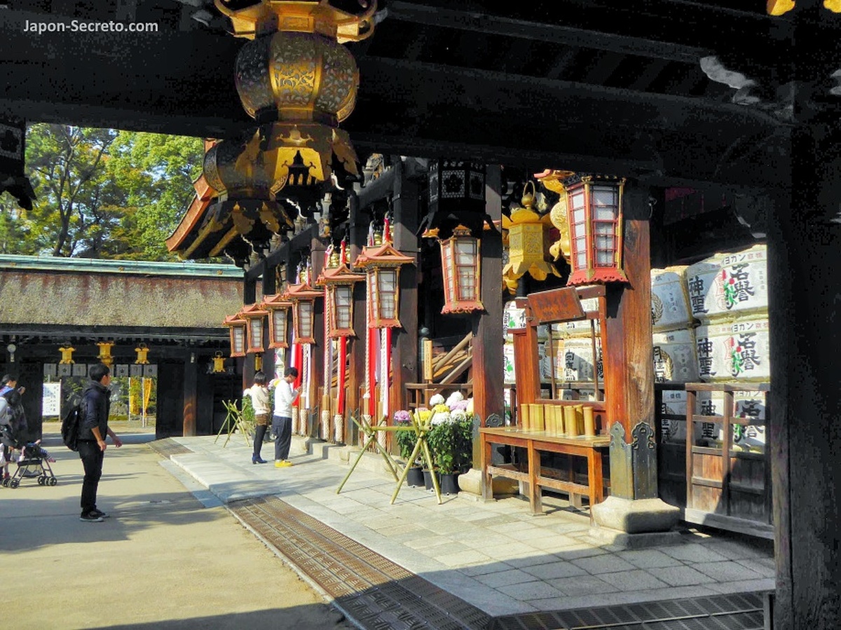 Santuario Kitano Tenmangū (北野天満宮) de Kioto: cómo llegar, qué ver, comprar entrada y precio, mercadillo, momiji. Foto: farolillos de madera y gente rezando frente al altar.