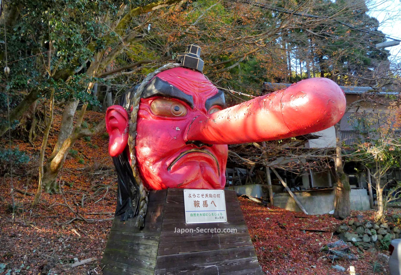 Estatua de la cabeza roja brillante de un tengu y su inconfundible larga nariz, símbolo de Kurama y situada a la entrada de la estación de tren
