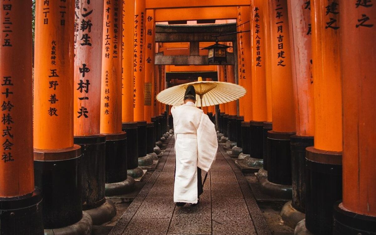 fushimi-inari002_1200x750 Guía de Kioto completa: lugares de interés, comida, alojamiento y transporte, itinerarios, consejos, eventos y tips. Foto: sacerdote sintoísta caminando por el túnel de toriis del santuario Fushimi Inari Taisha de Kioto