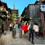 ¿Viajar a Japón por libre o con agencia en viaje organizado? consejos y mejores empresas de viajes. Foto: Jinrikisha (rickshaw) bajando por una callejuela del barrio de Higashiyama (Kioto) con la pagoda Yasaka al fondo