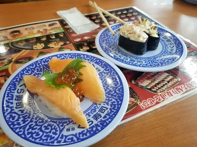 Kura Sushi (くら寿司), cadena de restaurantes de sushi giratorio (servido sobre cinta transportadora) bueno y barato