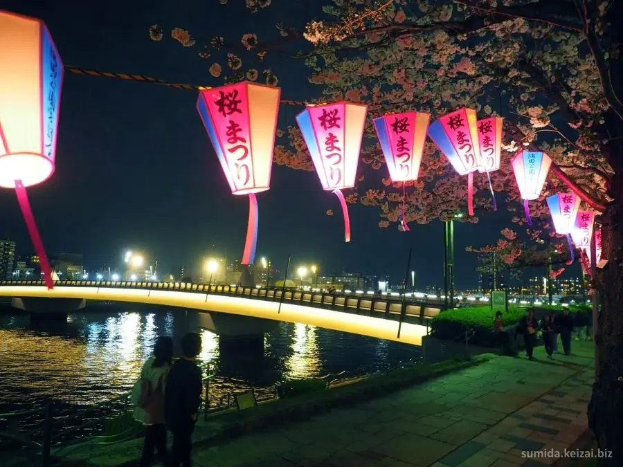 Yozakura o cerezos iluminados por la noche durante el Festival Bokutei Sakura Matsuri (墨堤さくらまつり) de cerezos en flor junto al río Sumida en Tokio