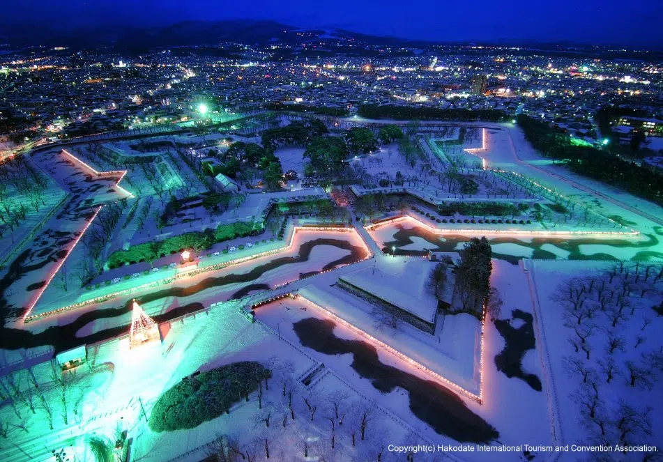 Yozakura (夜桜) o cerezos sakura en flor iluminados en el Parque Goryokaku (Hakodate, Hokkaido)
