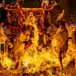 Impresionante imagen de personas cruzando el fuego con un mikoshi o santuario portátil durante el festival de fuego Shūki Reitaisai (秋季例大祭) celebrado en otoño en el Santuario de Kushida (櫛田神社) de la ciudad de Imizu (射水市), en Toyama