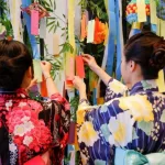Colgando cintas tanzaku durante la celebración del festival Tanabata en Japón, la fiesta de las estrellas, en verano